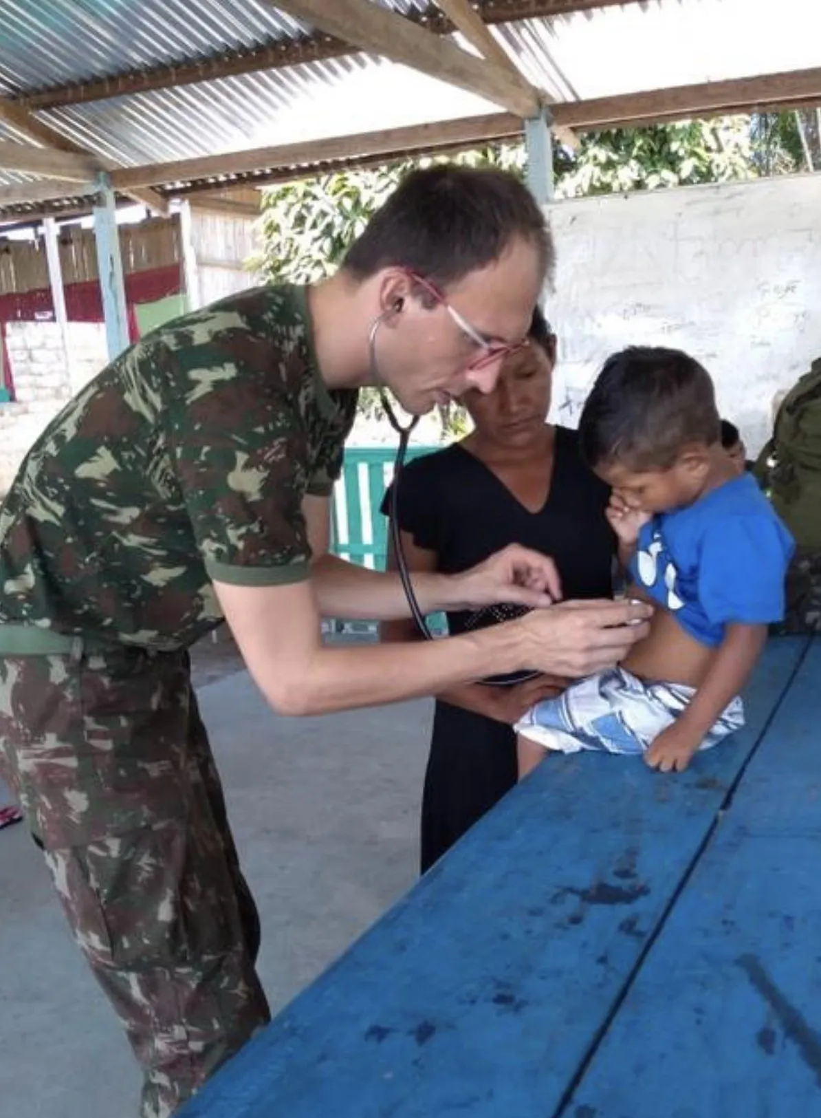 Dr. Roberto Gimena como médico do Exército atendendo uma criança na Amazônia