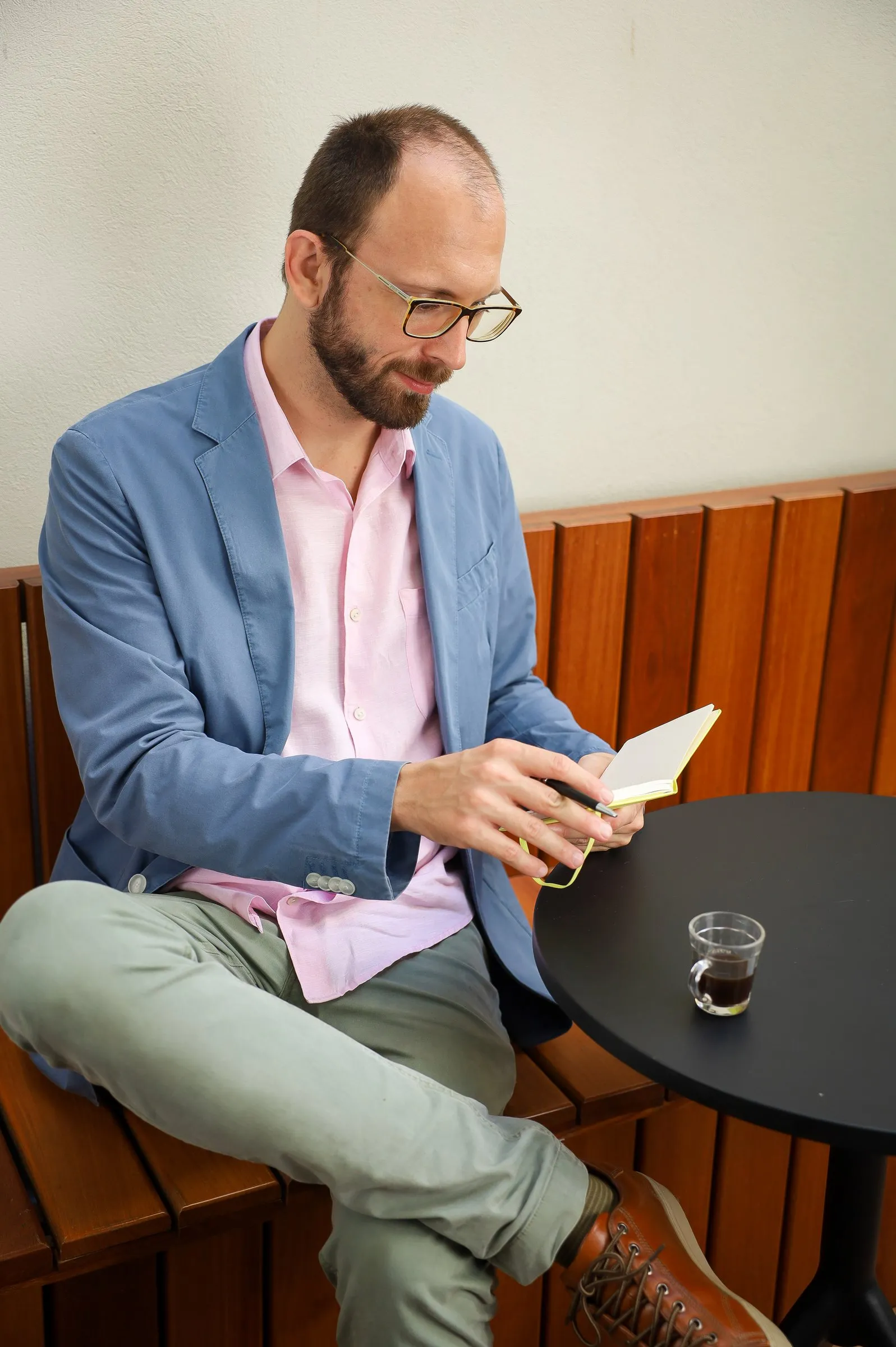 Dr. Roberto Gimena lendo um caderno com um café